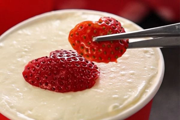 Сверху выровнять кремом по уровню стакана. Выложить клубнику или другие ягоды.