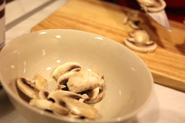 Шампиньоны нарежьте тонкими пластинками, обжарьте на оливковом масле в течение пары минут.