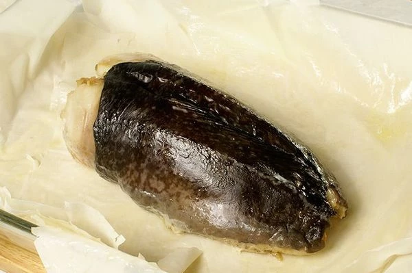 Готовый рулет из морского черта немного охладить, освободить от фольги, переложить в центр теста.