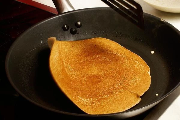 Перевернуть блин начинкой вниз и жарить до готовности.