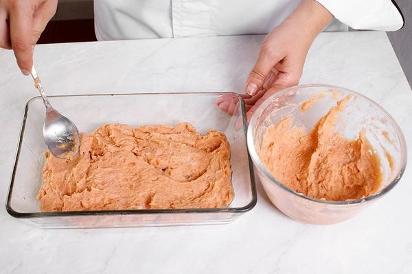 На смазанный оливковым маслом противень выложить половину красного фарша, разровнять.