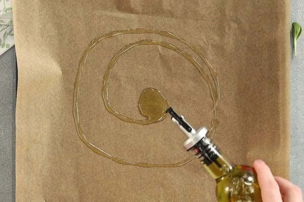 На противень выложить пергамент, смазать маслом. 