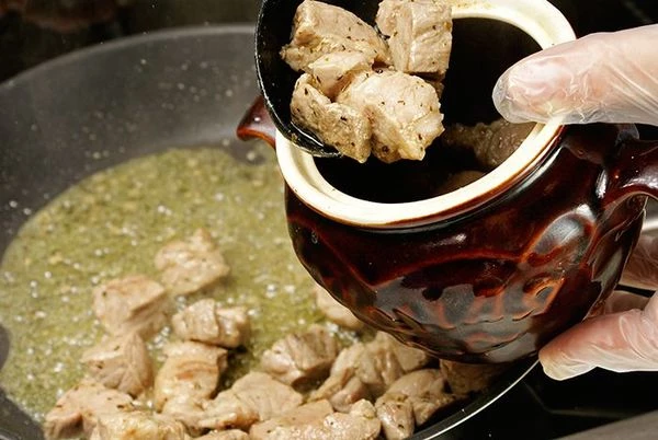 Переложить обжаренное мясо в горшочки