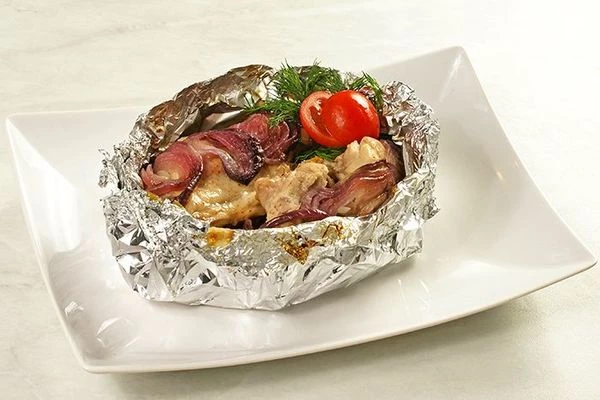 Разрезать аккуратно ножницами фольгу сверху (осторожно горячий пар), украсить получившееся блюдо зеленью и свежими овощами.