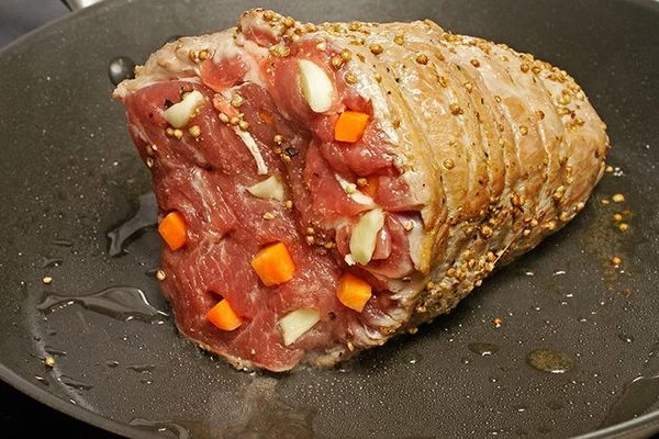 Обжарить нашпигованное мясо на разогретой с оливковым маслом сковороде со всех сторон, чтобы получилась румяная корочка. ( для того, чтобы сок при запекании остался внутри). Снять нитку.