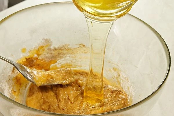 Влить к сахарно-яичной смеси мед, добавить размягченное масло.