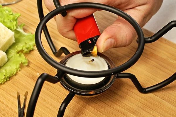 Чтобы сырная масса не остыла, поджечь специальную свечу, которая входит в набор.