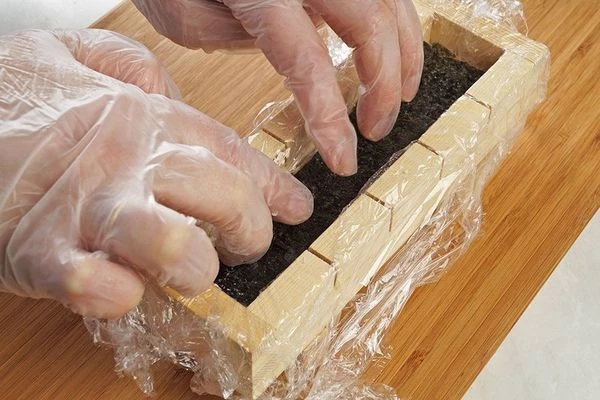 На соус положить полоску нори и слегка придавить пальцами.