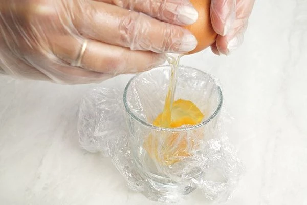 В это время приготовить яйцо "в мешочек". Для этого в кастрюле довести воду до слабого кипения. Влить 1-2 ст.л уксуса. В глубокую чашку выстелить пищевую пленку, разбить туда яйцо.