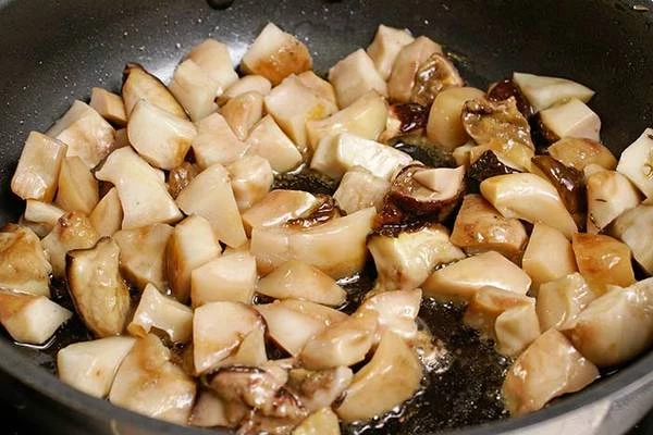 Кубики грибов обжарить на разогретой с оливковым маслом сковороде, посолить, поперчить, влить немного бульона и потушить под крышкой.