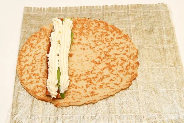 Аккуратно выдавите поверх угря и авокадо две полоски сливочного сыра с помощью кулинарного шприца или пакета