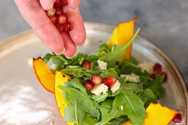 Брынзу измельчить в крошку. 
Гранат очистить.
На тарелку для подачи выложить тыкву. В нее выложить рукколу, брынзу, посыпать гранатом. 