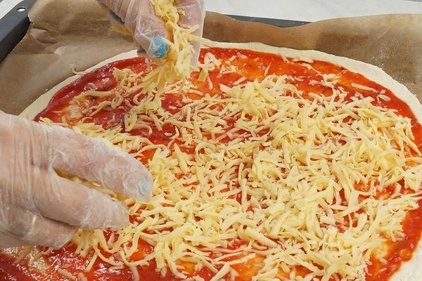  На соус распределить натертый сыр.