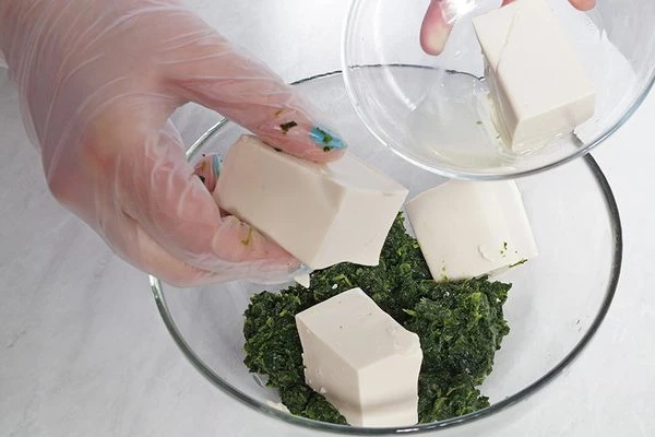 Смешать в глубокой миске шпинат и творог тофу.