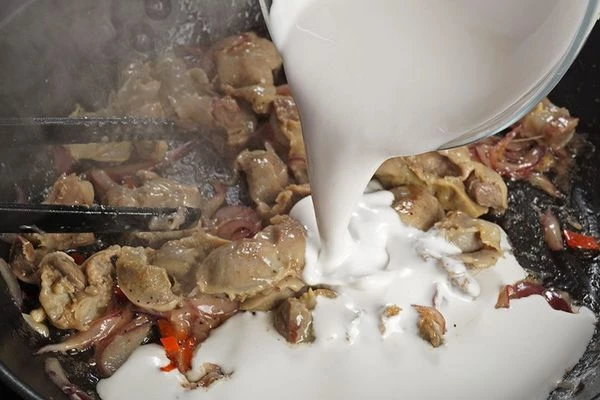 Влить кокосовые сливки, выпарить 3-4 минуты. Посолить, поперчить по вкусу.