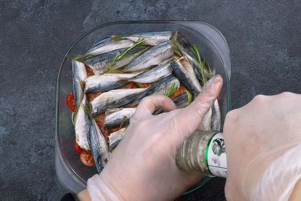  Сверху рыбу, веточки розмарина. Посолить по вкусу, сбрызнуть растительным маслом. Рыбу можно уложить вниз, но чтобы она была более плотная, мы ее выложили на овощи.