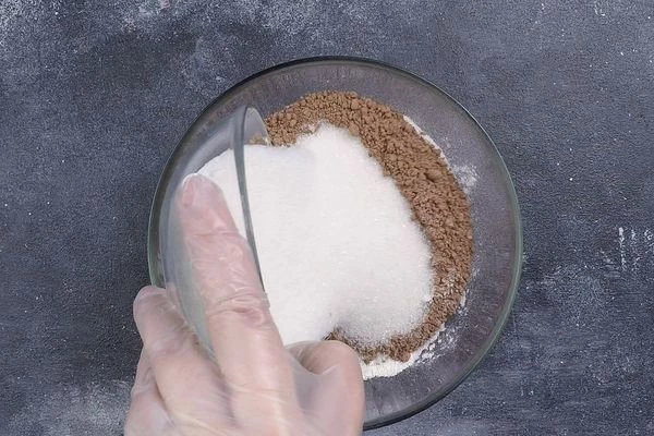 В глубокой чашке смешать муку, сахар, какао и разрыхлитель, перемешать.