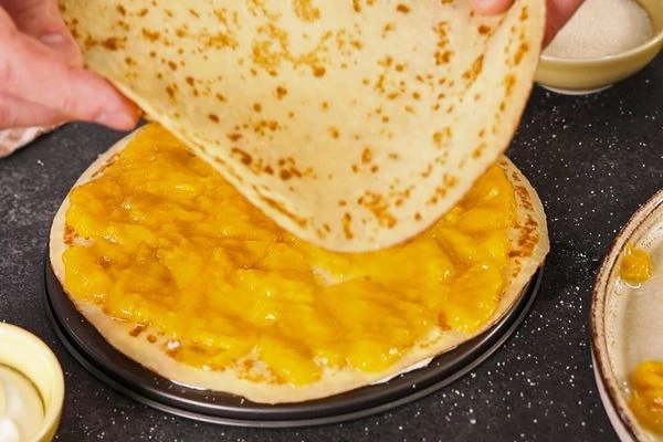 Выложить нарезанное манго и накрыть блинчиком.