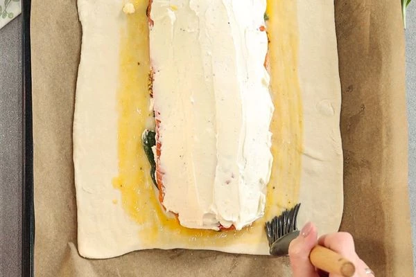 Свободные края теста смазать взбитым яйцом.