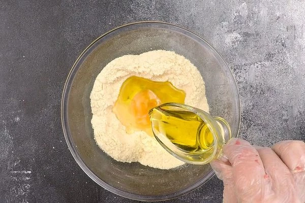 В это время сделать основное тесто: муку высыпать горкой на стол, сделать углубление, добавить яйцо, 1 ст.л оливкового масла. 