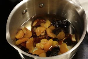 Приготовить кус кус с фруктами: сухофрукты нарезать на небольшие кусочки, удалить косточки. Положить в кастрюльку, залить вином.