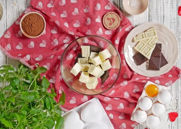 150 г темного и 30 г белого шоколада со сливочным маслом растопить на водяной бане. 