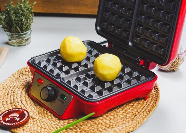 Картофель вымыть, очистить, отварить в подсоленной воде до готовности. Картофель сбрызнуть маслом и посолить. Вафельницу разогреть. Выложить в нее картофель, аккуратно прижать. 