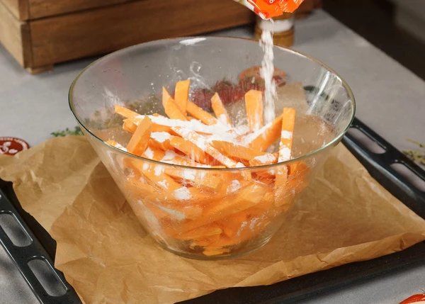 Переложить в миску, посолить, добавить масло, перемешать. Посыпать тертым чесноком, перемешать. Посыпать крахмалом и снова перемешать. 