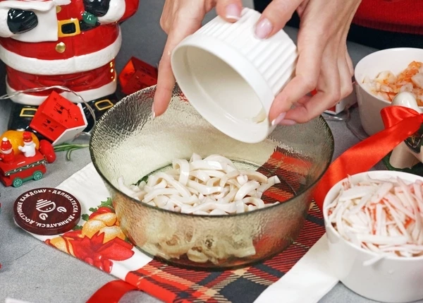 Кальмары разморозить. Отварить в подсоленной воде в течение 1,5 - 2 минут. Нарезать. Переложить в салатник.