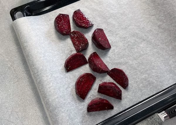 Свеклу вымыть, нарезать сегментами. Переложить в емкость, смешать с орегано, маслом, солью. На противень, застеленный пергаментом выложить свеклу, поставить в разогретую до 200 градусов духовку на 10 минут.