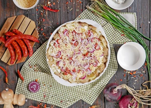 Сверху выложить нарезанный лук. Посыпать натертым сыром. Выпекать в разогретой до 180 градусов духовке в течение 15-20 минут. 