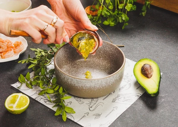 Маракуйю вымыть, разрезать пополам, мякоть выложить в глубокую тарелку.