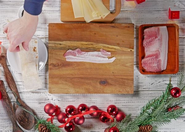 Лаваш порезать на тонкие полоски по размеру бекона. На доску выложить бекон. 