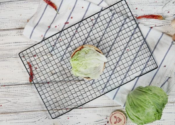 Нижнюю часть булочки смазать техасским соусом. Сверху выложить лист салата.