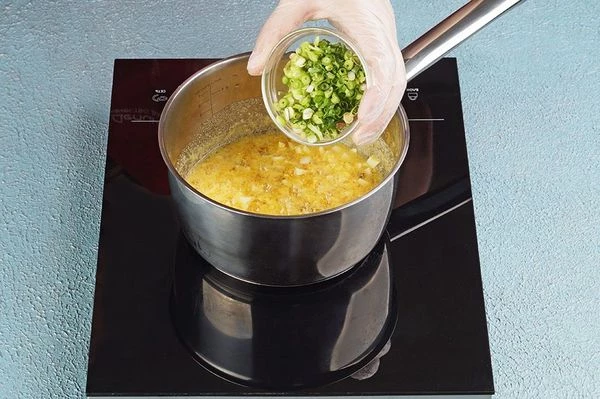 В конце добавить зеленый лук, хорошо перемешать. Довести до кипения и снять с огня.