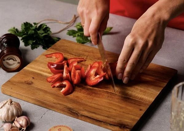 Перец вымыть, почистить от перегородок и семян и нарезать крупной соломкой.