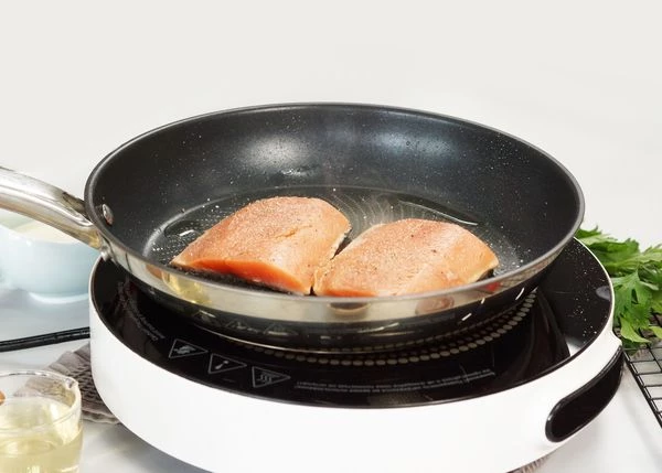 Филе горбуши разморозить на нижней полке холодильника. Нарезать на порционные куски. Обжарить по 1,5 минуты с каждой стороны на оливковом масле, посолить и поперчить.