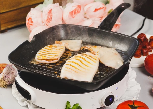 Кальмары разморозить на нижней полке холодильника. Очистить. Выложить на разогретую сковороду гриль с маслом. Жарить по 1,5 минуты с каждой стороны. Посолить. Снять со сковороды. 