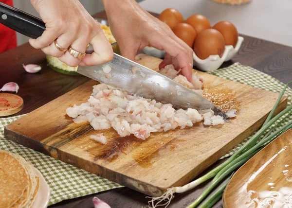 Филе минтая разморозить на нижней полке холодильника. Нарезать мелким кубиком, посолить, поперчить и перемешать. 