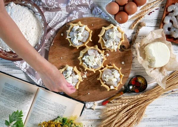 Выложить на креветки нарезанный чеснок, сбрызнуть оливковым маслом, посыпать сыром. 

