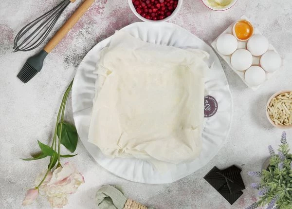 Накрыть вторым листом и снова промазать маслом. Повторить со всем тестом.