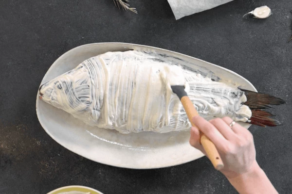 Подготовленную рыбу смазать смесью сметаны  и соевого соуса.
