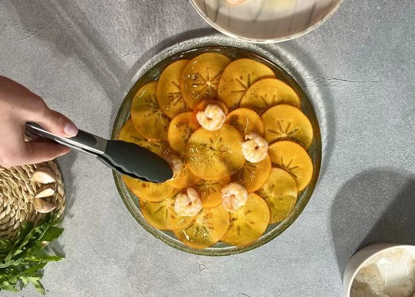 Сверху выложить обжаренные креветки.