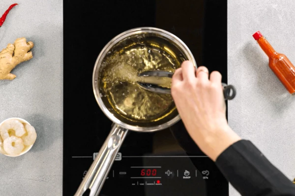 В сотейнике разогреть масло. Обжарить креветки в тесте до готовности. 
Готовые креветки переложить на салфетку, чтобы убрать излишки масла.
