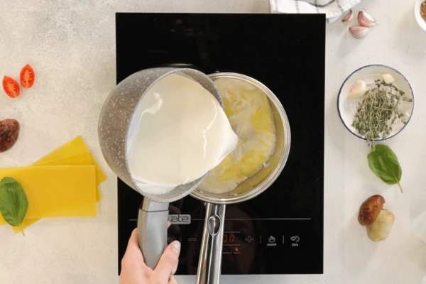 Предварительно подогреть сливки, влить в сотейник с мукой и маслом, перемешать.