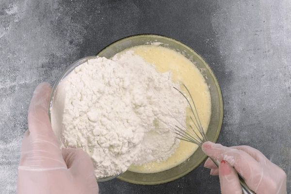 Затем постепенно всыпать муку.