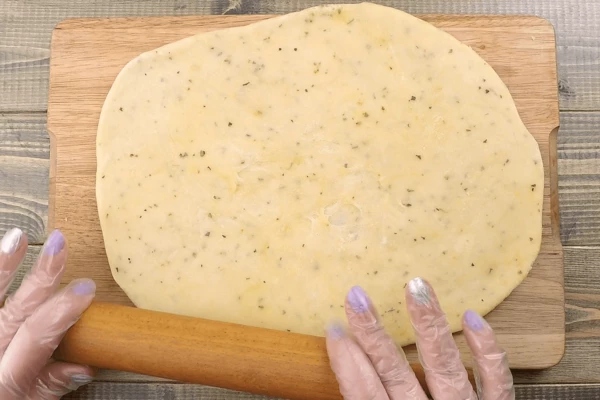 Раскатать получившееся тесто толщиной 5-6 мм, выложить на противень.