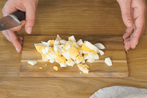 Яйца нарезать крупным кубиком, одно целое яйцо отложить для подачи (на две порции).