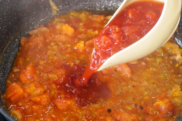 Добавить половину  томатов в собственном соку и томатную пасту, перемешать, томить 3 минуты. Затем добавить молотый мускатный орех, соль, черный молотый перец  и сахар, перемешать.