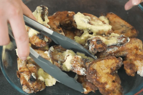 Готовые крылья обвалять в заправке, дать постоять пару минут.
